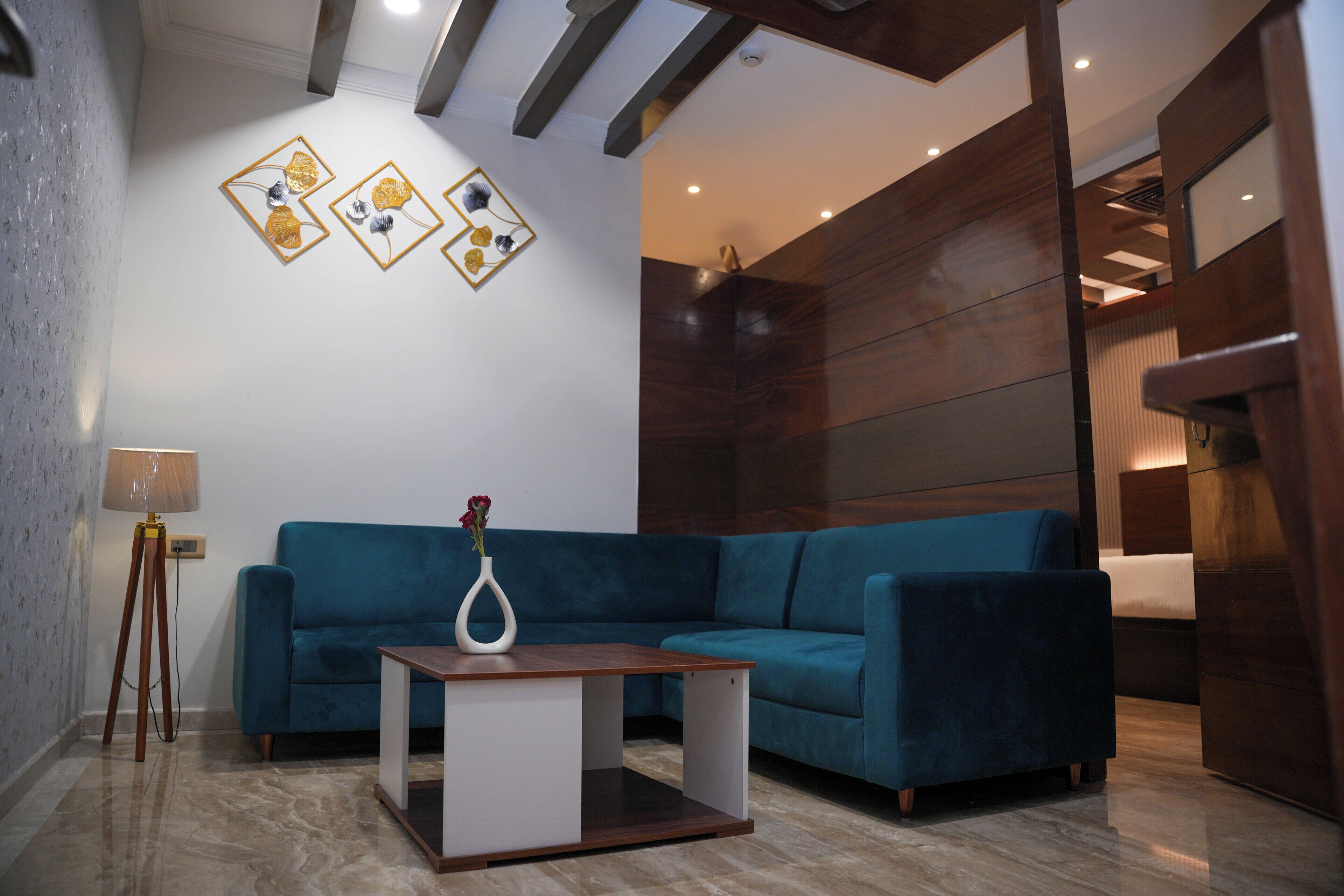 A modern living room with a blue sofa, a wooden coffee table, and a floor lamp.