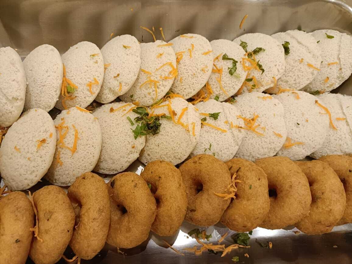 Un plateau contenant divers aliments, notamment des en-cas blancs et bruns, décoré de fromage râpé et d’herbes aromatiques.