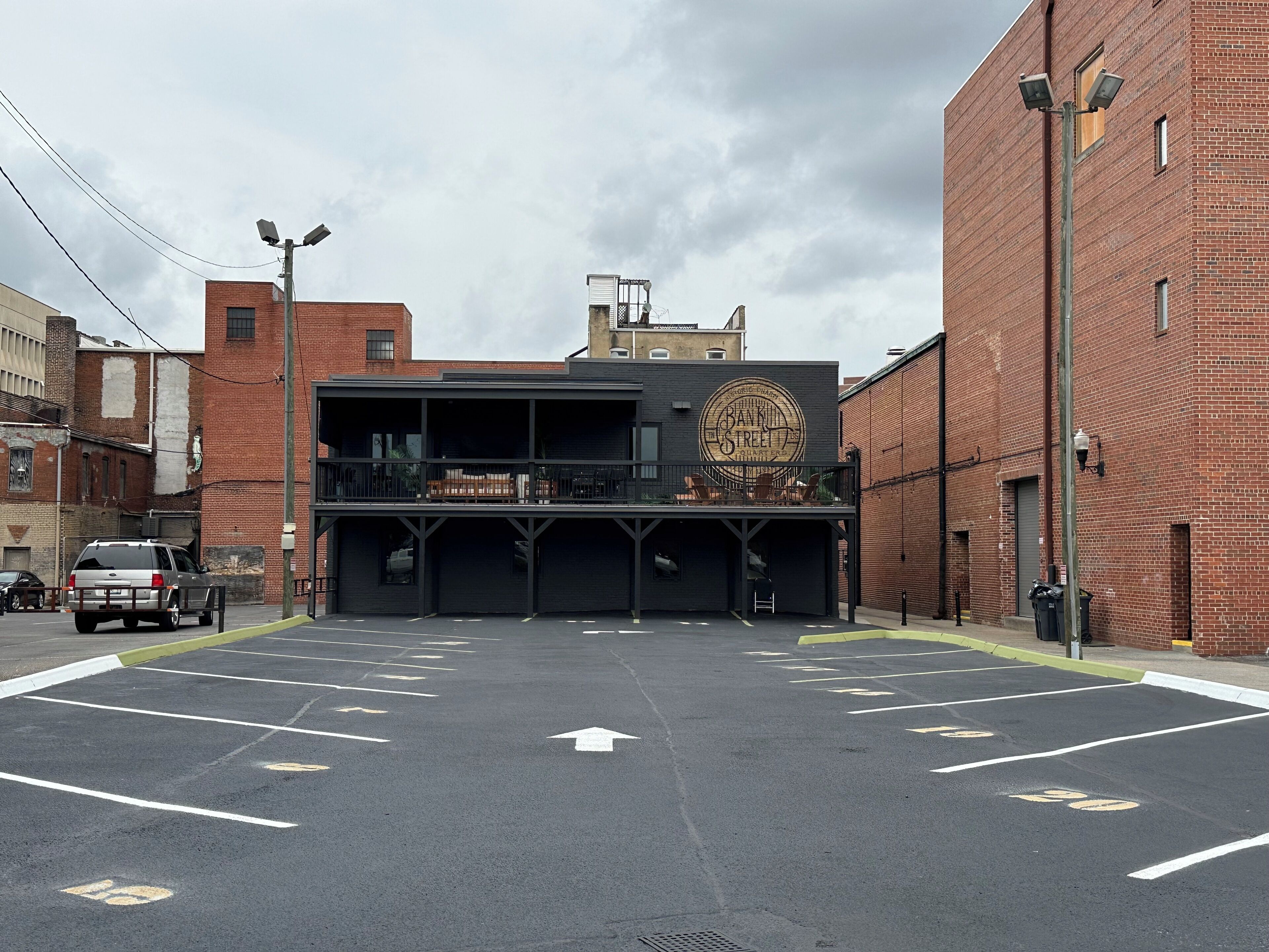 A parking lot with marked spaces and a building with a mural.
