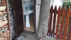 A rustic outdoor area with a wooden fence, a tree, and a potted plant. - Feel surrounded by nature. Pets allowed (Sežana)