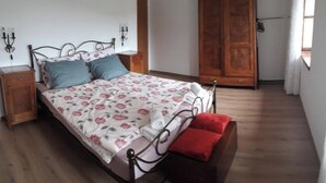 A bedroom with a bed, nightstands, a wardrobe, and a window. - Feel surrounded by nature. Pets allowed (Sežana)