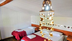 Ein Hotelzimmer mit zwei Einzelbetten, einem Holzkopfteil, einer Hängelampe und einer Wand mit Muster.
