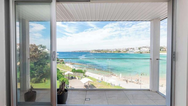 A balcony with a view of a beach and ocean. - Ocean view luxury 3 bedroom home with balcony (North Bondi)