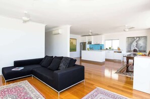 Relax in this stylish living space with a comfortable sofa and modern kitchen area.