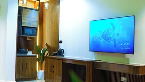 Ein modernes Wohnzimmer mit einem Flachbildfernseher, Holzkästen und einer Zimmerpflanze.