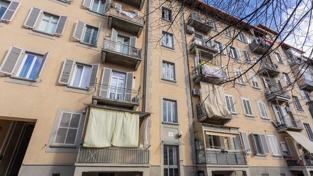 A multi-story residential building with balconies, a bicycle parked outside, and a bench. - Frejus Apartment by Wonderful Italy (Turin)