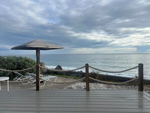 A wooden deck with a rope barrier, a shaded area, and a view of the ocean. - 2-bed loft-style condo sleeps six, WiFi, pool, AC; walk to restaurants & beach (Frigate Bay)