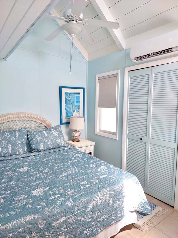 A bedroom with a bed, a ceiling fan, a window, and a door. - 2-bed loft-style condo sleeps six, WiFi, pool, AC; walk to restaurants & beach (Frigate Bay)
