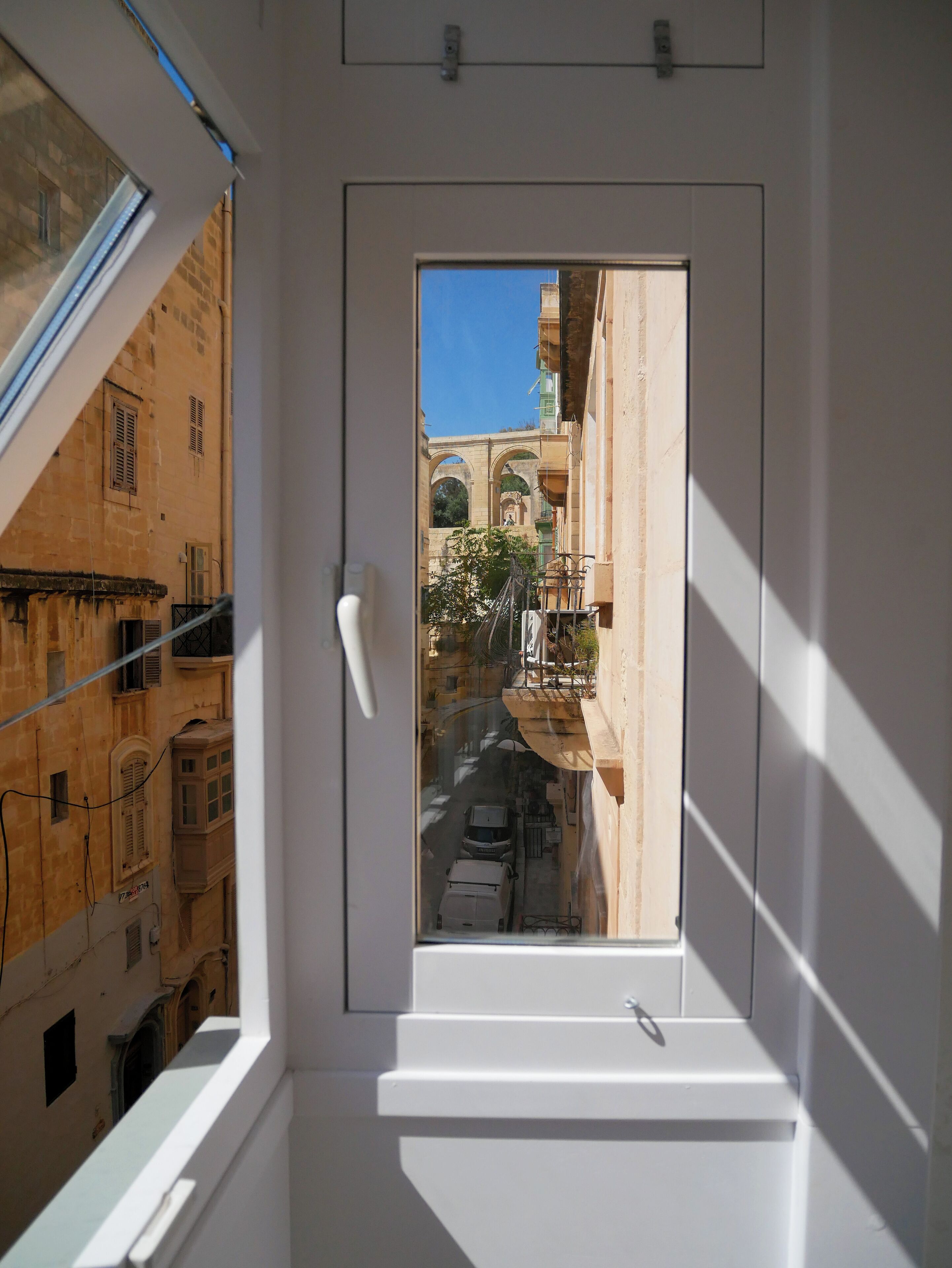 Un pasillo estrecho con vistas a edificios históricos y un arco.