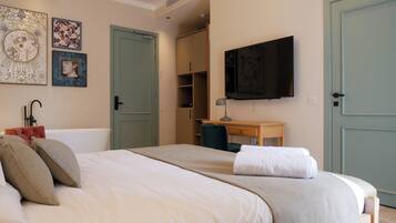 A bedroom with a bed, a desk, a television, and a wardrobe.