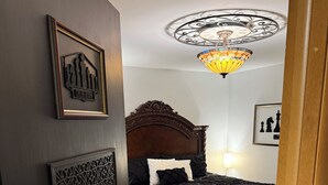 A bedroom with a dark wooden bed, a patterned wall, and a chandelier. - the HUB - Fun Board Game 1980s Vibe @ Letchworth - 8 mins SUNY Geneseo - 3BD 2BA (Mount Morris)
