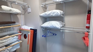 A walk-in closet with multiple shelves for storage, a wooden door, and a red hanger rack. - Auburn First Floor Condo. Walking Distance To Jordan Hare and Auburn Arena (Auburn)
