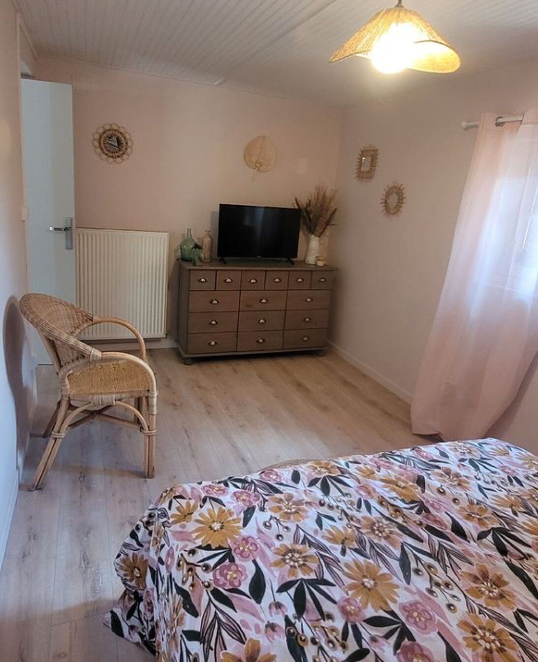 Una camera da letto con un letto, una cassettiera, una sedia e un televisore.