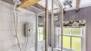 A shower with a handheld showerhead and a wall-mounted control panel. - 2 bedroom accommodation in Burgh Le Marsh (Burgh Le Marsh)