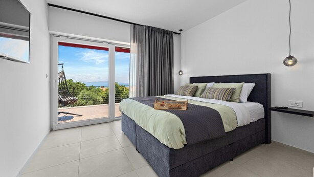A modern bedroom with a large bed, a sliding glass door to a balcony, and a view of the outdoors. - Apartment Klara - beautiful pool apartment for 7 people (Rabac)