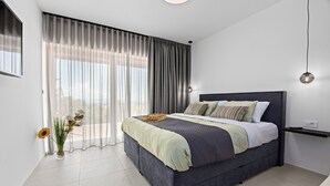 A modern bedroom with a large bed, a bedside table, and a view of the outdoors through sheer curtains. - Apartment Klara - beautiful pool apartment for 7 people (Rabac)