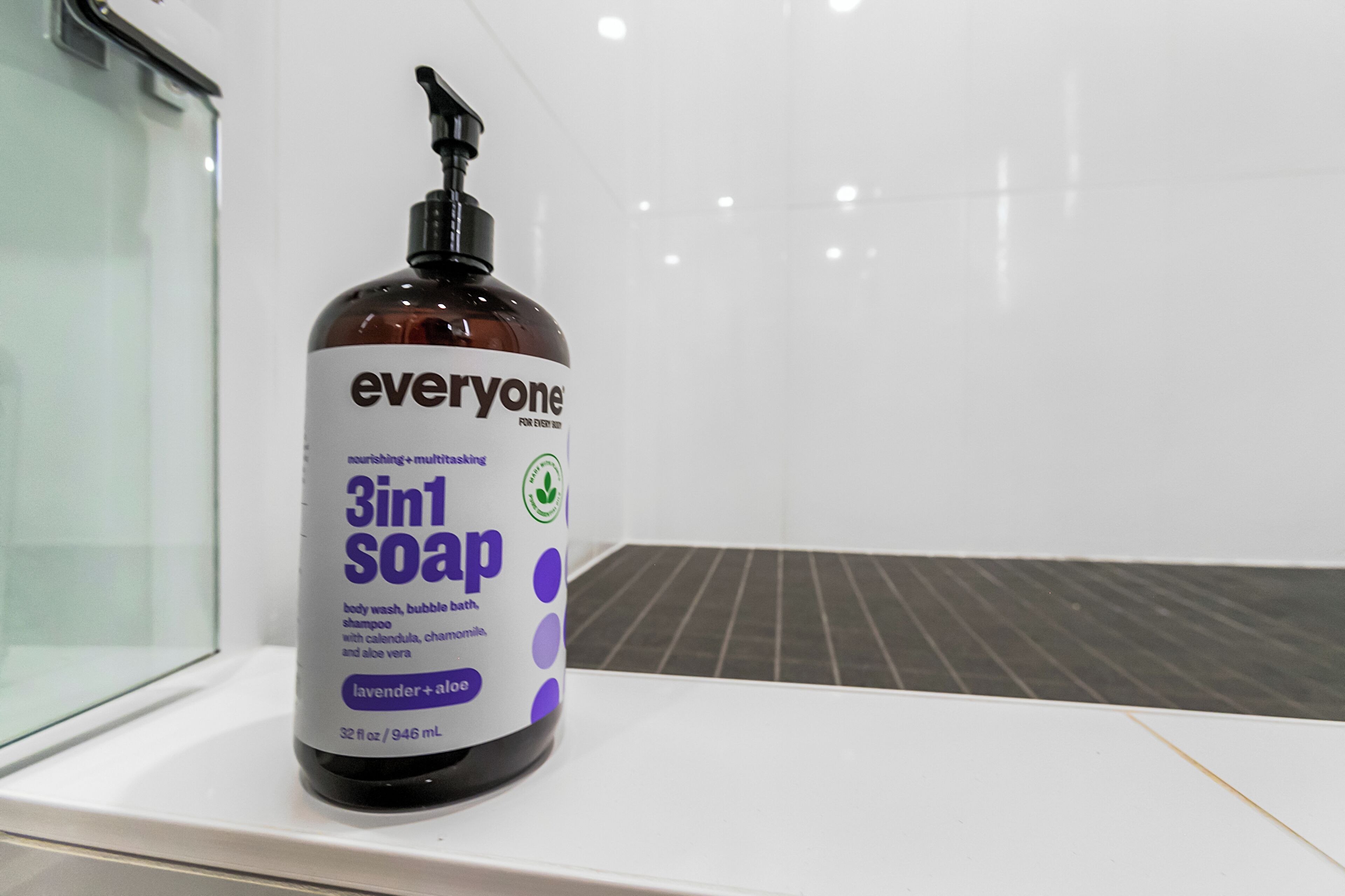 A bottle of 3in1 soap on a white shelf in a bathroom.