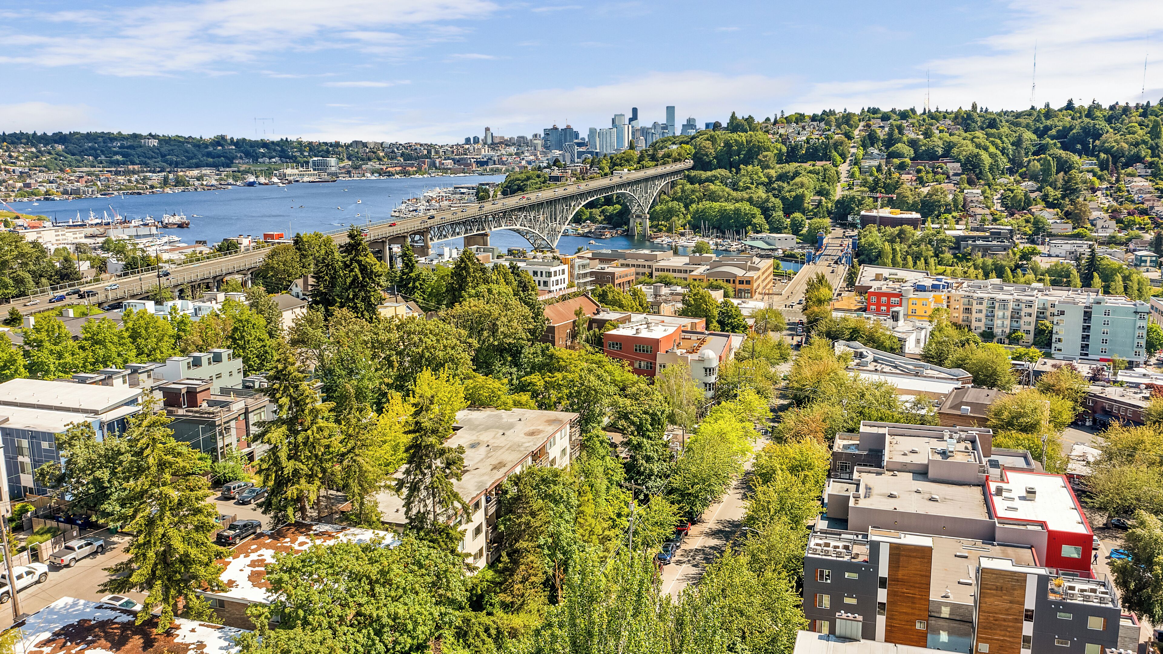 A cityscape with a prominent bridge, dense urban buildings, and a waterfront area.