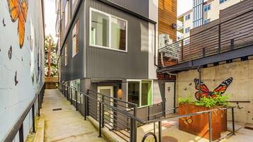 A modern building with a staircase, a butterfly mural, and a planter with greenery.