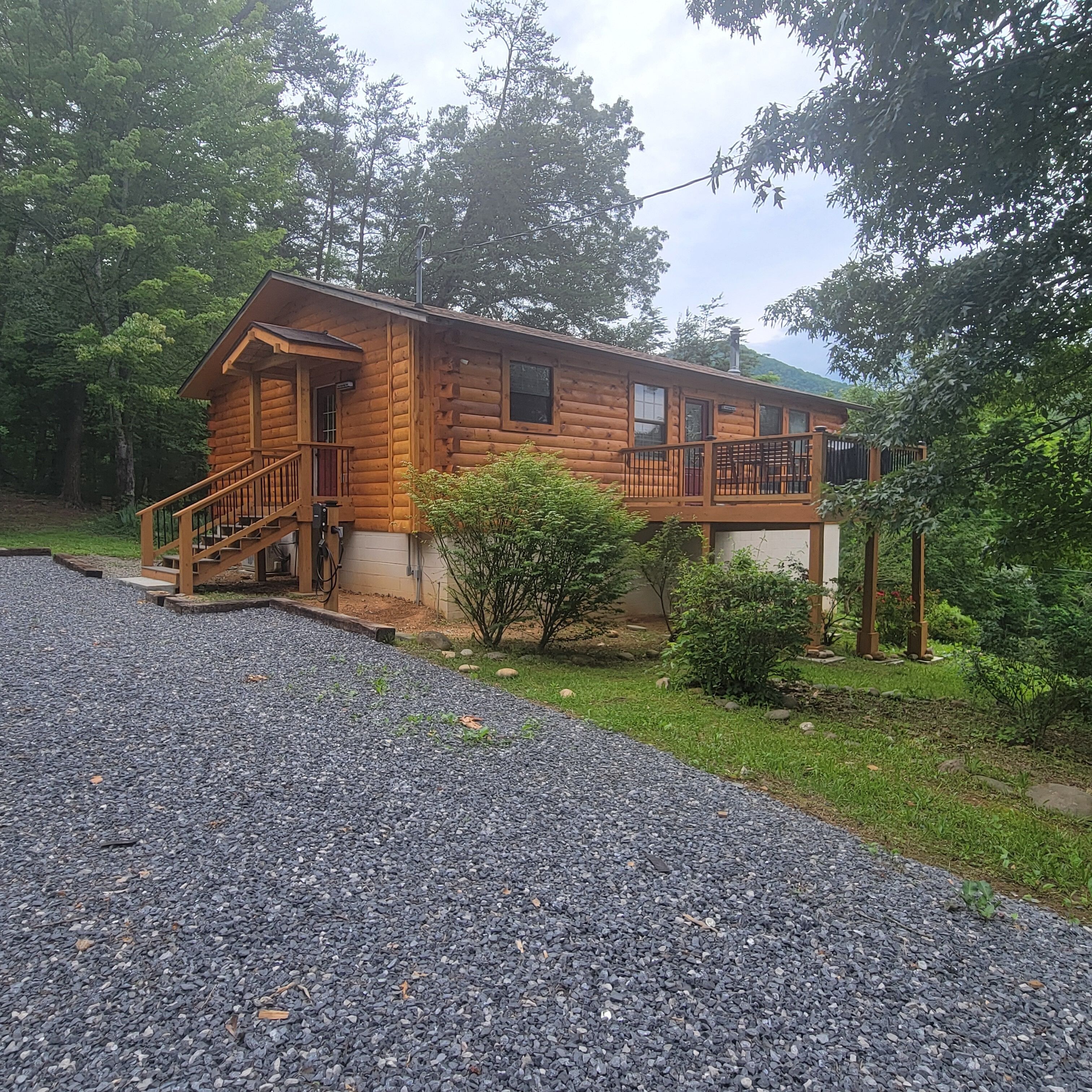 A wooden cabin with a porch, a staircase, and a small deck.