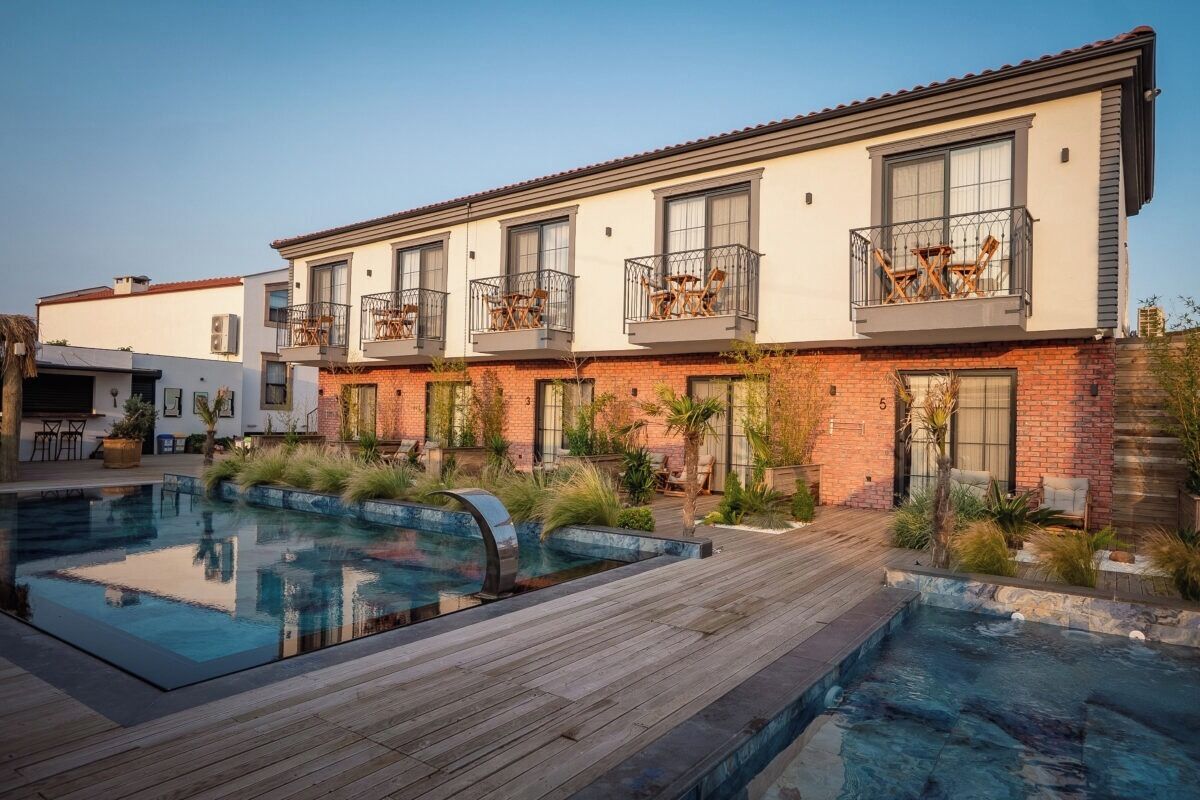 Une maison moderne à plusieurs étages, dotée d’une piscine, d’un espace salon extérieur et d’un patio.