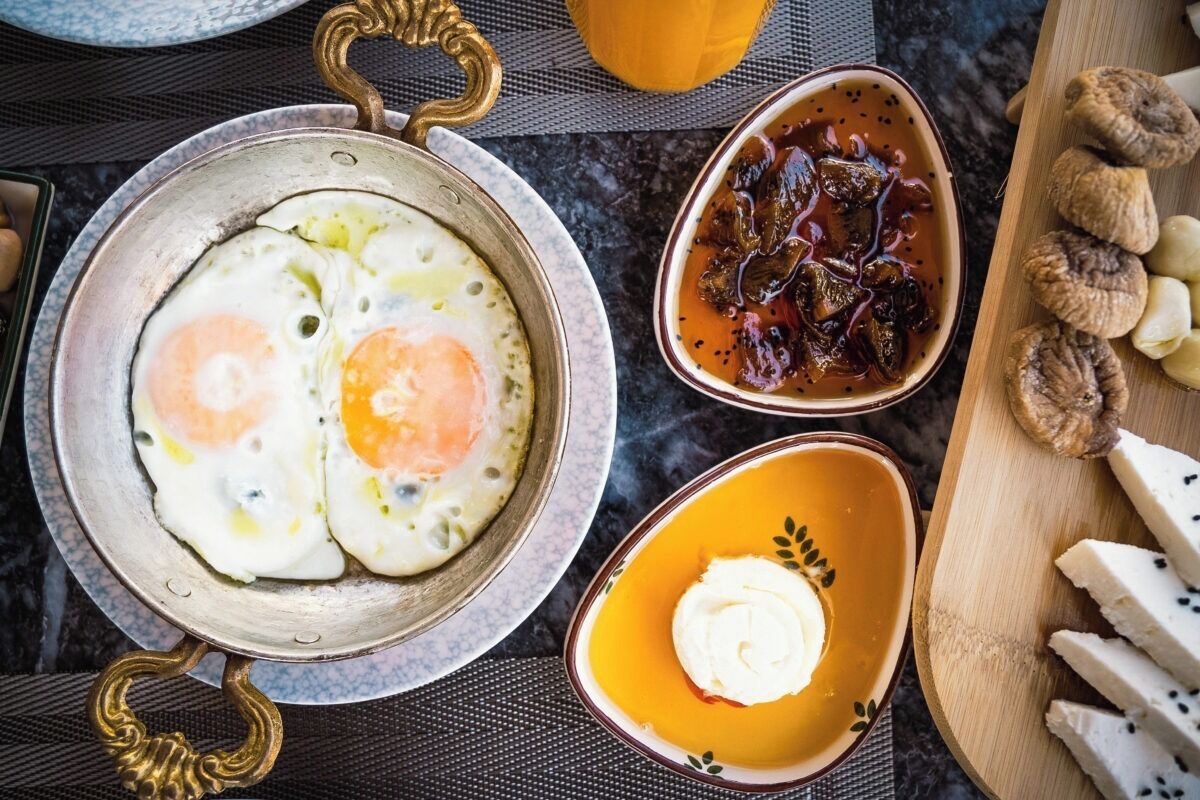 Un plateau de petit-déjeuner comprenant des œufs, un bol de sauce et des tranches de pain.