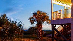 A wooden deck with a railing, a palm tree, and a clear sky. - Oceanfront | Quiet Beach | 2 Balconies | Arcades | Kayaks (Port St. Joe)