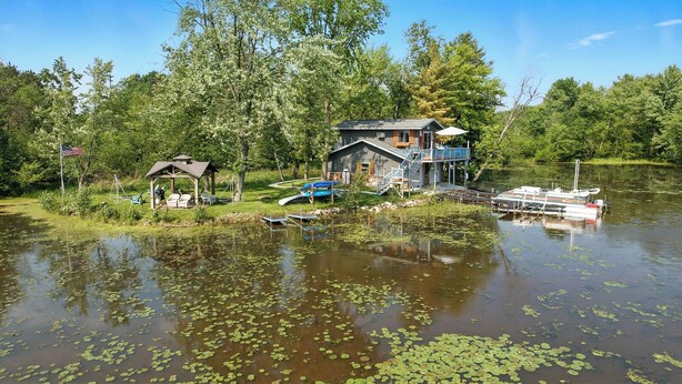 A lakeside cabin with a dock, a covered boat ramp, and a small gazebo. - Bay Loft Couples Retreat – Nature, Comfort & Charm (Stevens Point)
