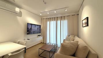 Departamento Deluxe, 1 cama King size y sofá cama, cocina, vista a la ciudad | Área de sala de estar | Smart TV de 55 pulgadas con canales por cable