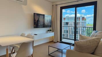 Deluxe appartement, 1 kingsize bed met slaapbank, keuken, uitzicht op de stad | Woonruimte | Een 55-inch smart-tv met kabelzenders