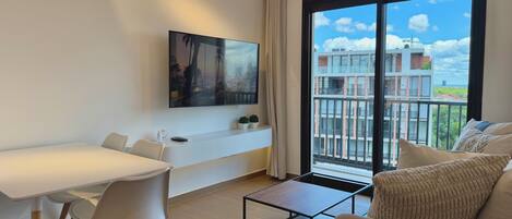 Deluxe-huoneisto, 1 suuri parisänky ja vuodesohva, keittiö, kaupunkinäköala | Oleskelualue | 55–tuumainen äly-TV, jossa kaapelikanavat