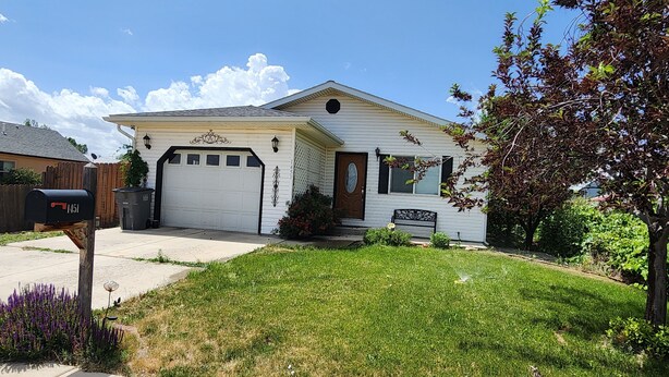 A single-story house with a garage, a front porch, and a well-maintained lawn.