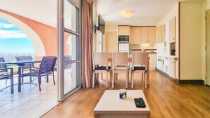 Un apartament modern amb zona de dinar, cuina i un balcó amb vistes.