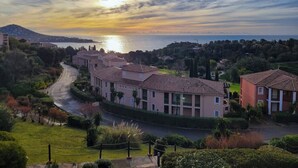 Zona residencial a la costa, amb edificis, un carrer i vista al mar.