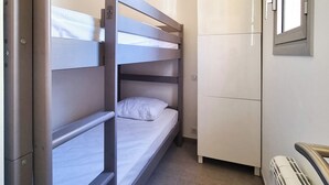 A bunk bed room with a wardrobe and a radiator. - Seafront apartment 4 people - 2 Pools (Saint-Raphaël)