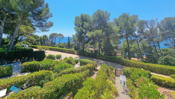 A landscaped garden with pathways, neatly trimmed hedges, and tall trees. - Seafront apartment 4 people - 2 Pools (Saint-Raphaël)