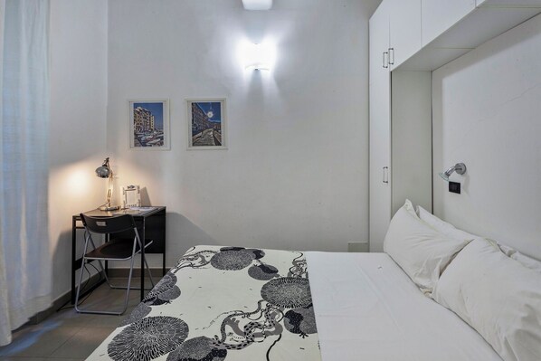 A hotel room with a bed, a desk with a chair, and two framed pictures on the wall. - A Un Passo dalla Spiaggia di Camogli by Wonderful Italy (Camogli)