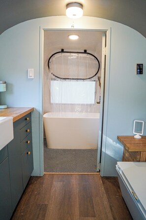 Un baño pequeño con bañera, cabina de ducha y tocador con cajones.