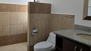 A bathroom with a toilet, sink, and shower area. - Casa Mandarina Junge Villa 3 pools (Veintisiete de Abril)