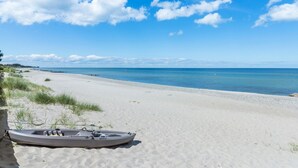 Ein Strand mit einem Ruderboot namens SEAFLO im Sand.