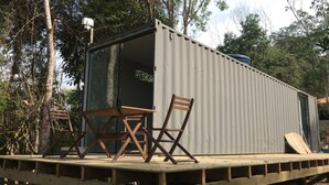 Un pequeño espacio al aire libre con una mesa y dos sillas sobre una plataforma de madera.