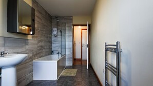 A modern bathroom with a sink, bathtub, and shower. - The Blissful Heaven (Manchester)