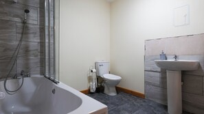Un bagno con vasca, WC e lavandino.