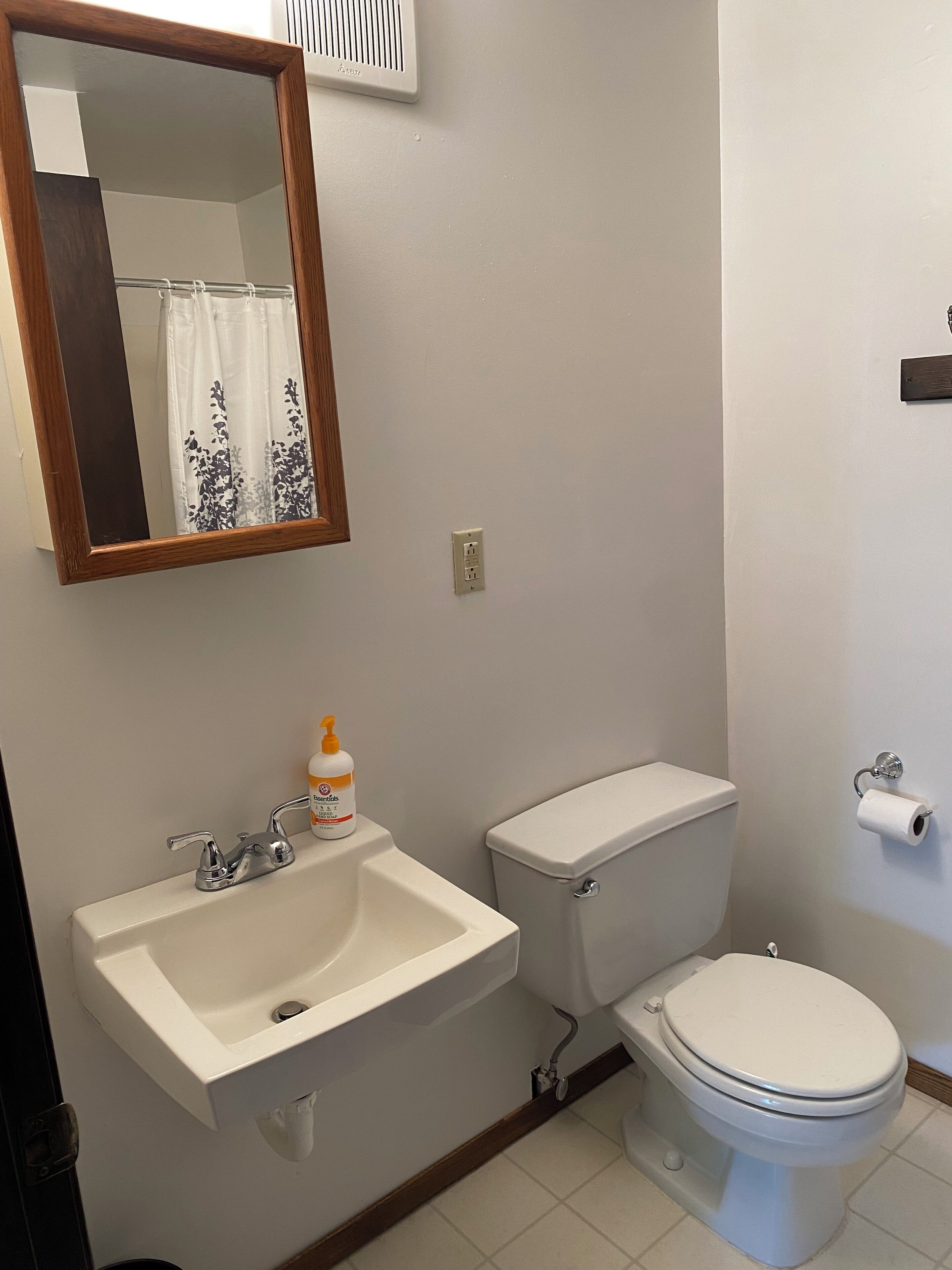 Un bagno con lavandino, WC e specchio.