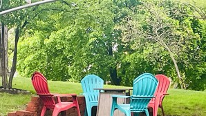 An outdoor seating area with a table and chairs, surrounded by lush greenery. - Near Huron Lake & downtown  (Port Huron)