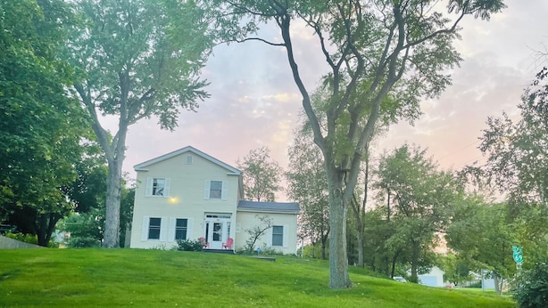 A two-story house with a front porch, surrounded by a well-maintained lawn and large trees. - Near Huron Lake & downtown  (Port Huron)