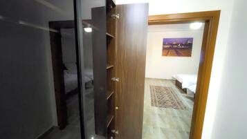 Une pièce avec un lit, une armoire en bois et un tableau au mur.