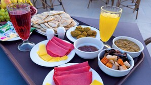 A tray with various food items including sliced meats, cheeses, and vegetables, along with drinks and condiments. - Sneferu Pyramids Golden Gate (Giza)