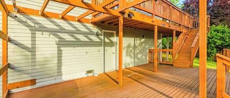 A wooden deck with a staircase leading to a covered area.