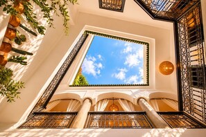 A room with a skylight, columns, and a decorative iron grille. - Riad Belvi - Breakfast - 10mn Jemaa El Fnaa-Pool (Marrakech)